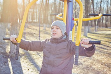 Adam parkta bir spor simülatörü yle meşgul.