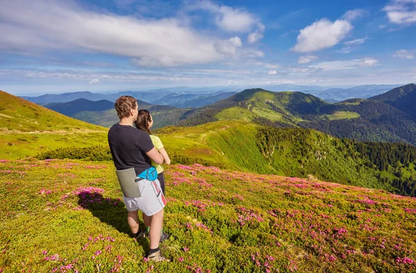 Hombre y mujer de pie y abrazándose en la cima de la montaña, s — Foto de Stock