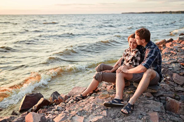 Loving couple in checkered shirts stands on the shore of the lak — Stock Photo, Image