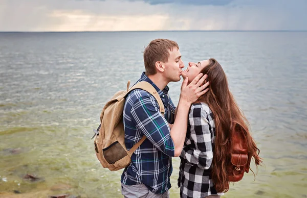 Pár turistů, kteří se líbají na břehu jezera — Stock fotografie