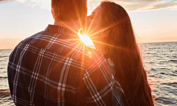 Liebespaar küsst sich bei Sonnenuntergang ins Wasser — Stockfoto