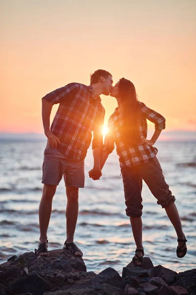 Pareja de amantes besándose en el agua al atardecer — Foto de Stock