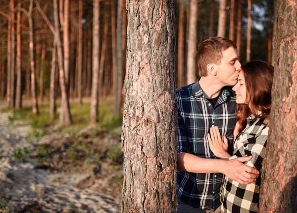 Młody człowiek całuje dziewczynę w parku — Zdjęcie stockowe