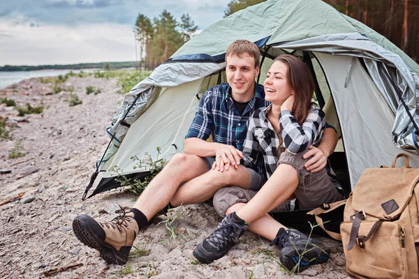 Pareja acampando. Jóvenes sentados en tienda — Foto de Stock