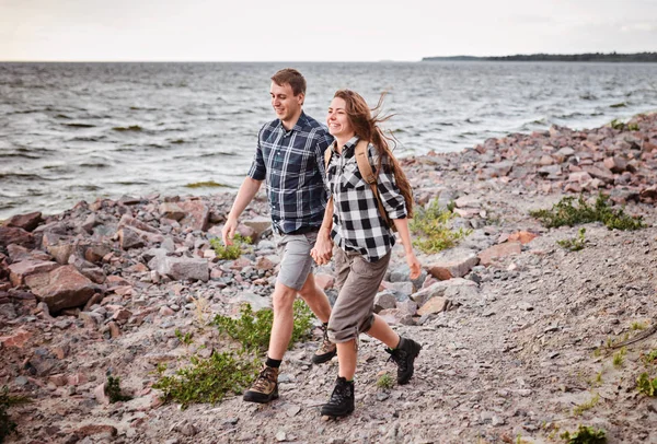 Feliz pareja corriendo cerca del lago — Foto de Stock