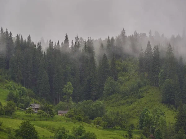 Bergslandskap i dimman. hus i bergen. — Stockfoto