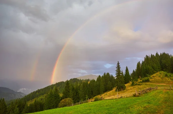 Morning fog with red hot sunrise and rainbow in the mountains — Stock Photo, Image