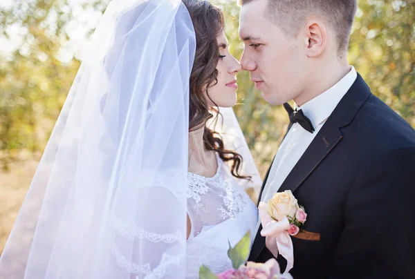 Paar im Hochzeitskleid mit einem Blumenstrauß — Stockfoto
