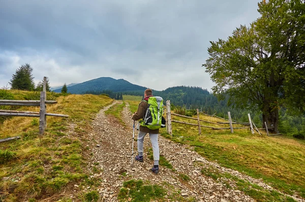 Senderismo de hombre en las montañas del atardecer con mochila pesada — Foto de Stock