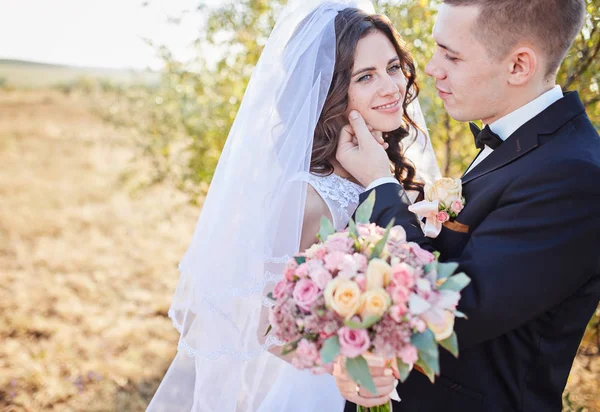 Elegante Braut und Bräutigam posieren zusammen im Freien — Stockfoto