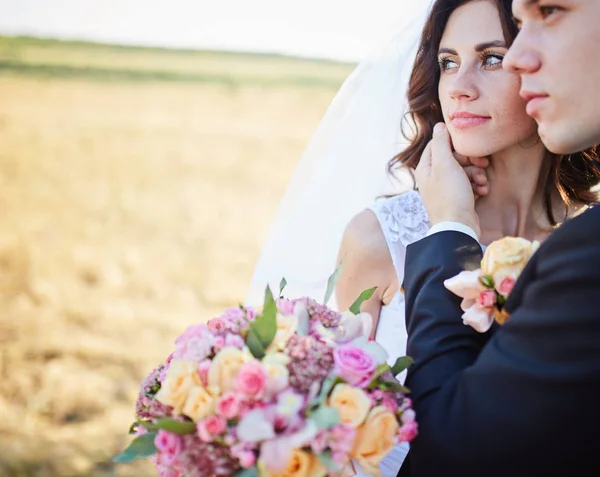 Элегантные невеста и жених позируют вместе на открытом воздухе — стоковое фото