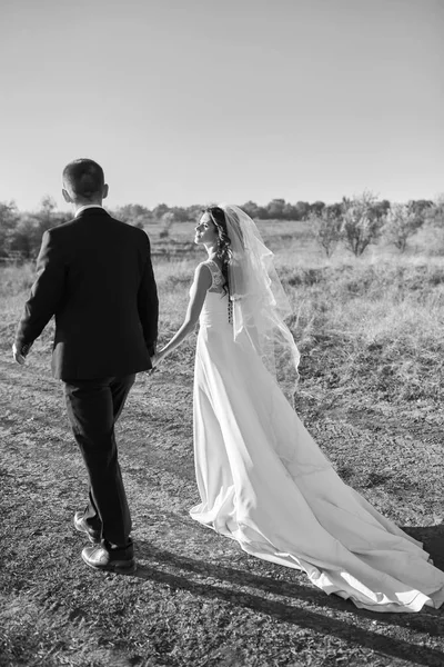 Casal em traje de casamento com um buquê de flores — Fotografia de Stock