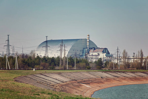 nuclear reactors of Chernobyl power plant next to Pripyat river, 4th (exploded) reactor with sarcophagus on left, 3th reactor on right, Exclusion zone, Ukraine