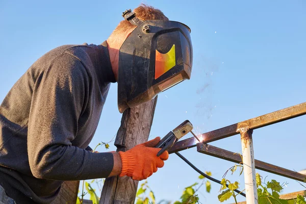 Soldador trabajador de acero de soldadura de trabajo en la industria con máscara de seguridad — Foto de Stock