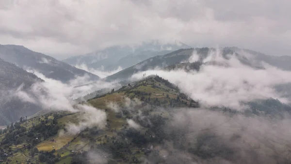 Europe de l'Ouest terrain montagneux et villages alpins sur fond de crêtes baignent dans la mer de brouillard après la pluie — Photo