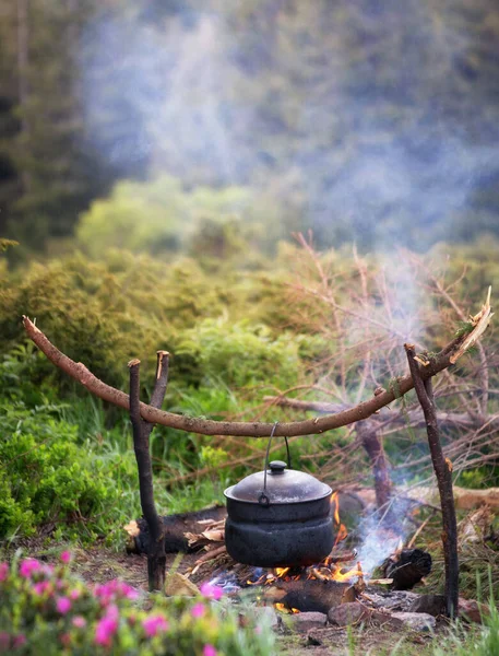 Wasserkocher im Wald bei Wanderung oder Trekking in der Natur in Flammen. — Stockfoto