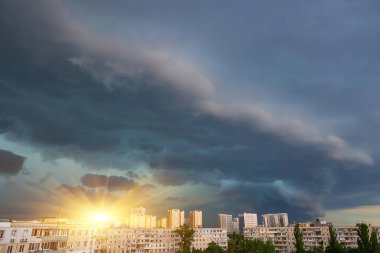 Devasa, iyi tanımlanmış bir süperhücre fırtınası şehrin silueti üzerinde kaygı verici bir şekilde belirir dramatik ve tehditkar bir atmosfer manzarası yaratır. Güçlü hava.