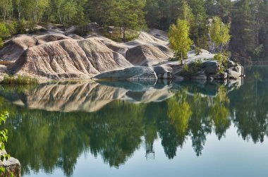 Kuru çimenler ve küçük ahşap bir kulübeyle sonbahar yamacından görünen adalarla geniş nehir manzarası. Huzurlu kırsal görünüm.