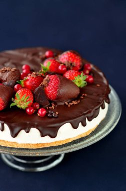 Bir cam pasta tutucu üzerinde çikolatalı çilekli pasta