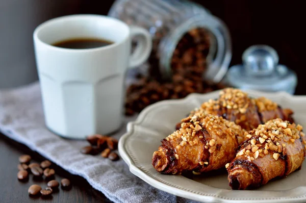 Küçük kruvasan ve kahve ile kıyılmış fındık serpilir