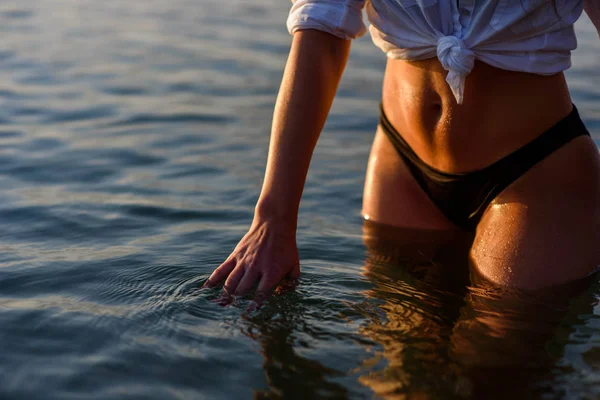 海の水に触れる手と美しい女性の体 ストック画像