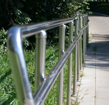 Güneşli yaz gününde parkta metal çitler