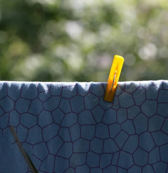 One clothespin on blue bedsheet — Stock Photo, Image