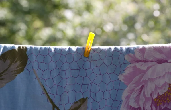Une pince à linge sur drap de lit bleu — Photo