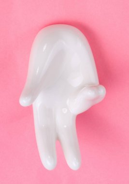 Pembe arka planda el şekli olan seramik standı