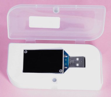 gün, pembe bir arka plan üzerinde plastik durumda elektronik cihaz