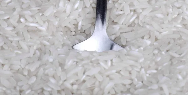 Rice background and teaspoon — Stock Photo, Image