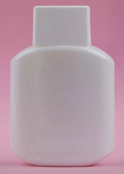 Парфюмерная бутылка на розовом фоне — стоковое фото