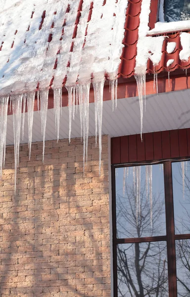 Eiszapfen auf Hausdächern am Wintertag — Stockfoto