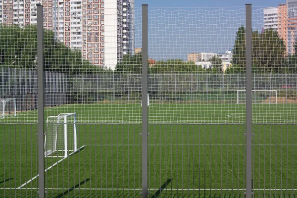 Güneşli bir günde çitin yanında futbol sahası — Stok fotoğraf