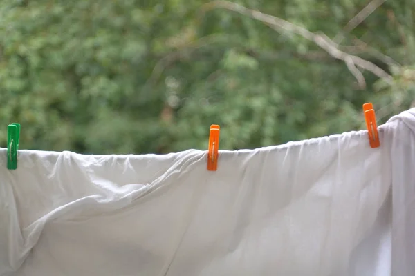 Three clothespin on white bedsheet — Stock Photo, Image