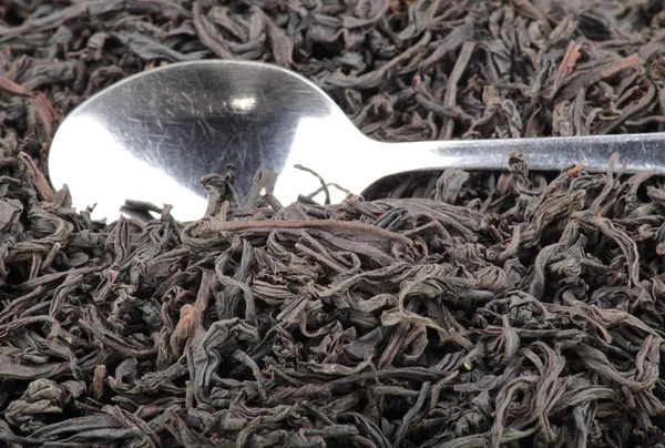 Black tee and teaspoon — Stock Photo, Image