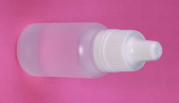Белый пластиковый Vial на розовом фоне — стоковое фото