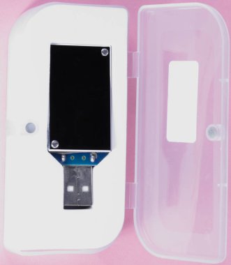 gün, pembe bir arka plan üzerinde plastik durumda elektronik cihaz