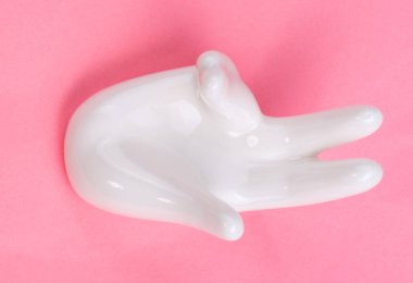 Pembe arka planda el şekli olan seramik standı