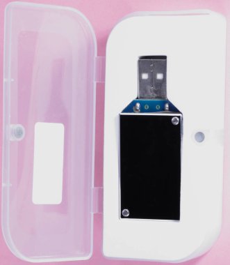 gün, pembe bir arka plan üzerinde plastik durumda elektronik cihaz