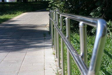 Güneşli yaz gününde parkta metal çitler