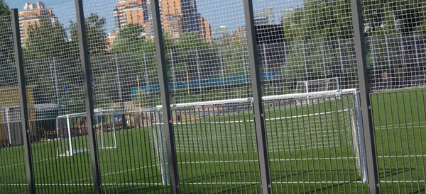 Fotbollsplan nära staket på dagen solig dag — Stockfoto