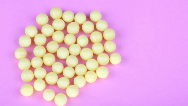 Gul vitaminer på rosa bakgrund — Stockfoto