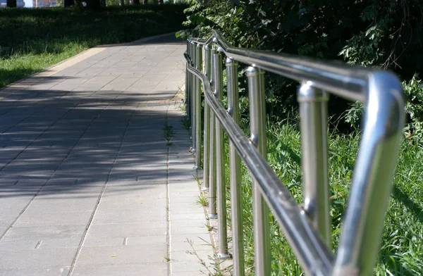 Metal fence in park at dry sunny summer day — Stock Photo, Image