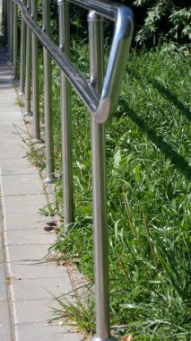 Güneşli yaz gününde parkta metal çitler