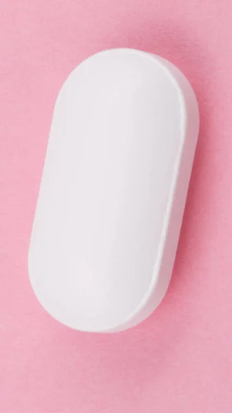 Píldora blanca sobre fondo rosa —  Fotos de Stock