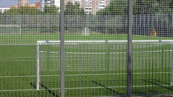 Güneşli bir günde çitin yanında futbol sahası — Stok fotoğraf