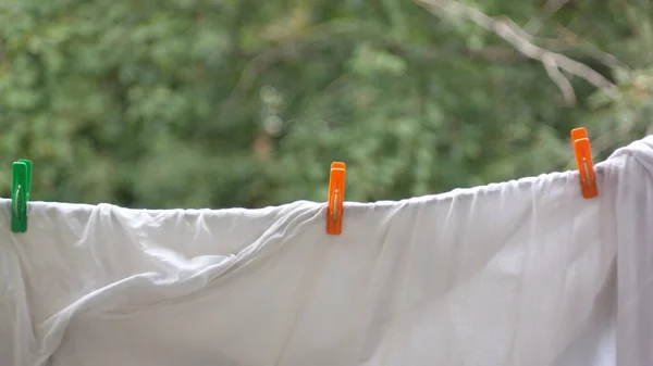 Three clothespin on white bedsheet — Stock Photo, Image