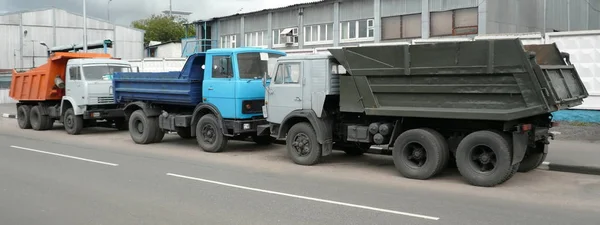 Серые, синие и оранжевые грузовики — стоковое фото