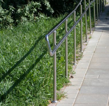 Güneşli yaz gününde parkta metal çitler